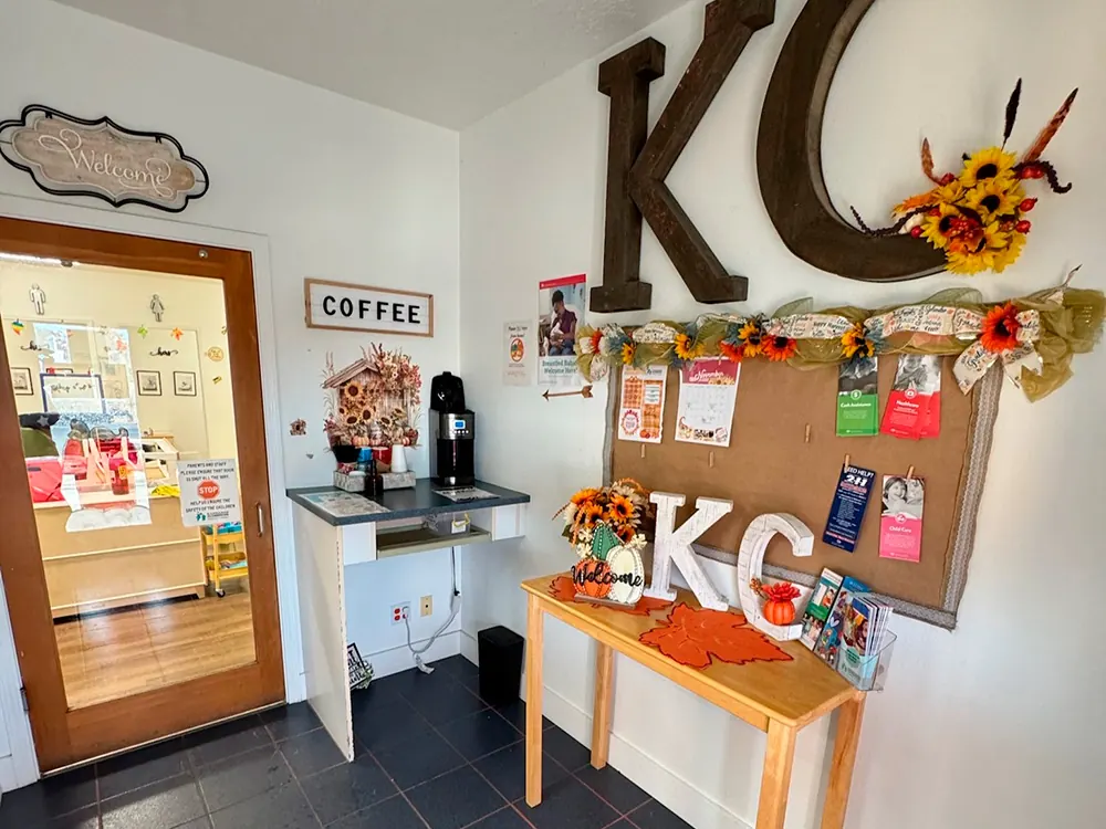 The center’s coffee nook, with a big “KC” sign, fall decorations and a parent notice board