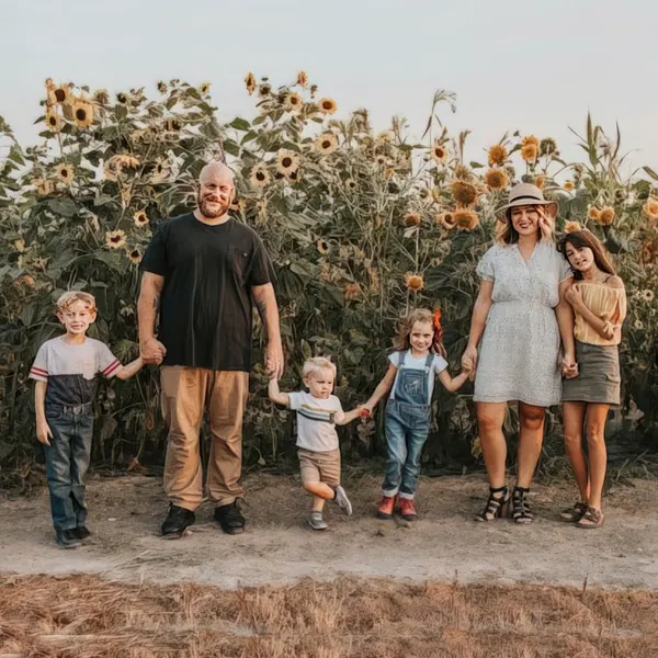 Owner Jennifer Koppes with her husband and four children, holding hands in front of a sunflower field