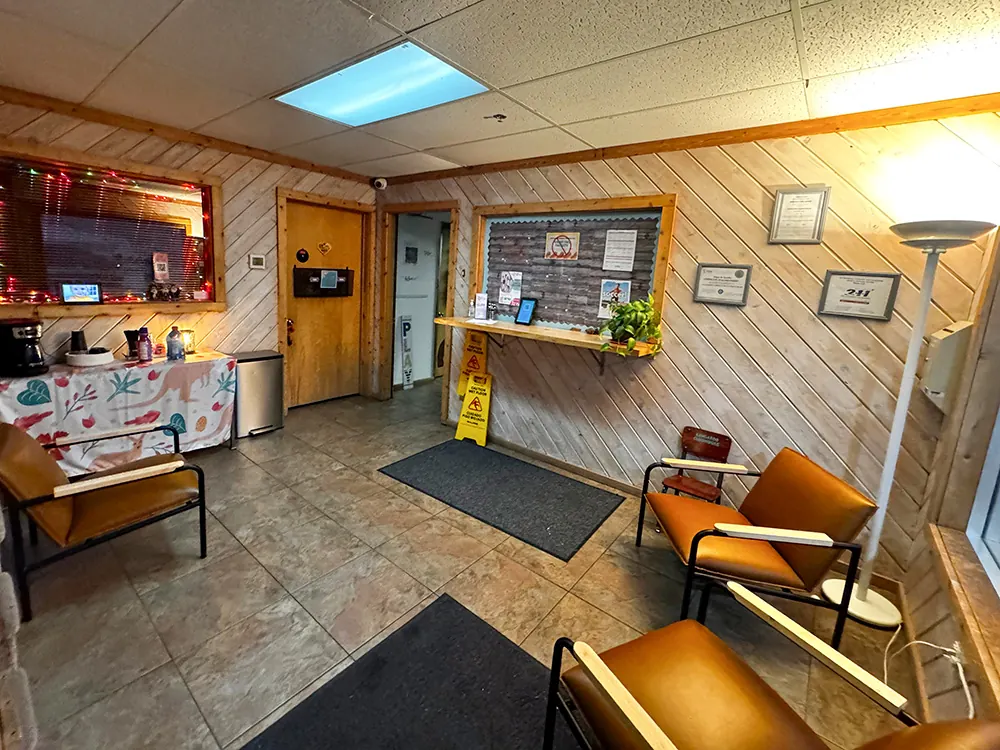 The center’s wood-paneled lobby with orange armchairs, a coffee station and a parent notice board