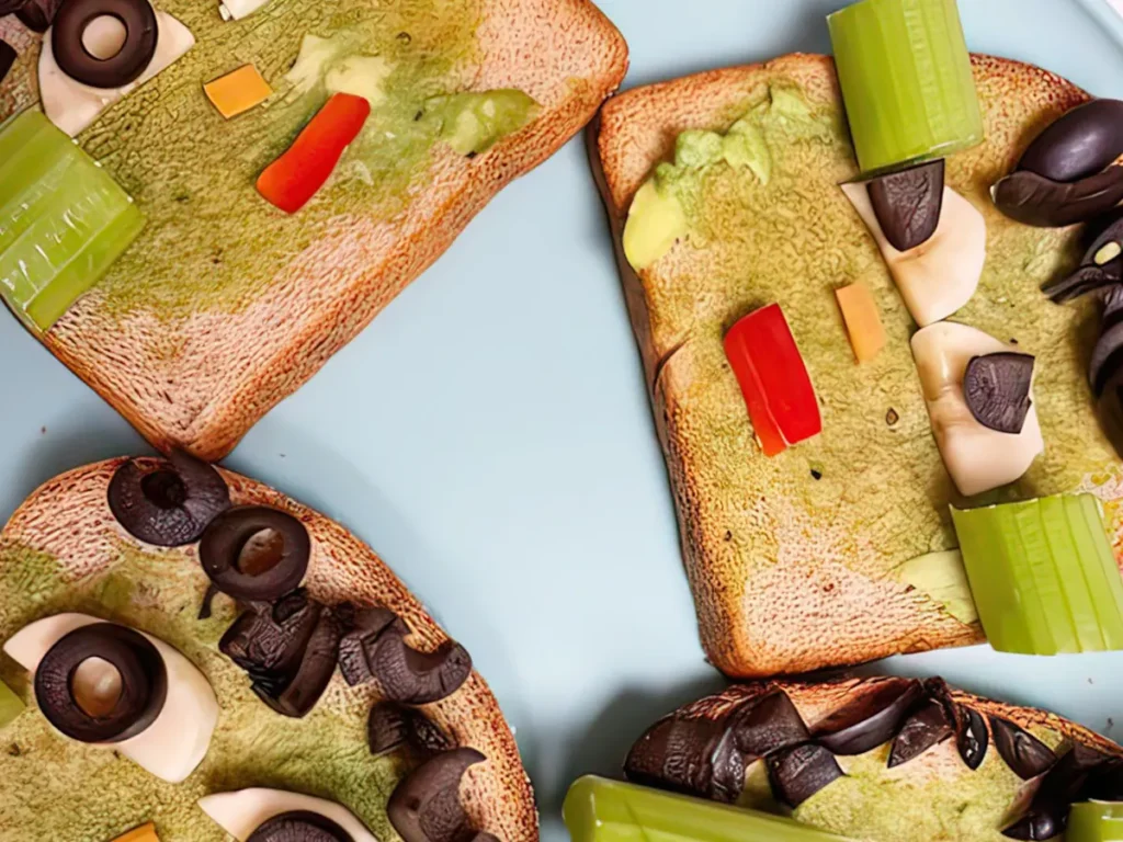 Slices of toast topped with avocado and vegetables arranged into faces