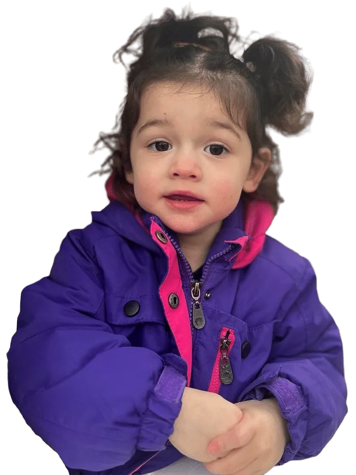 A smiling little girl with pigtail buns in a purple-and-pink winter jacket