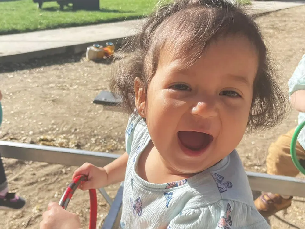 A laughing toddler girl on a playground